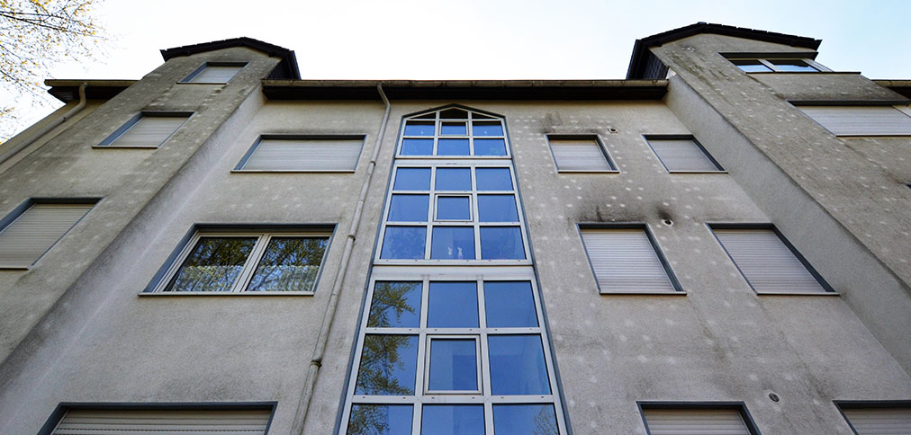 Mehrfamilienhaus Fassade vor und nach der Reinigung – vorher