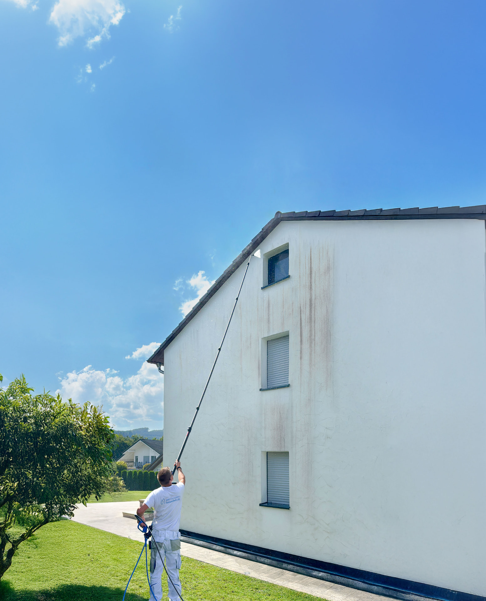 Fassadenreinigung an einem Einfamilienhaus mit Teleskoplanze